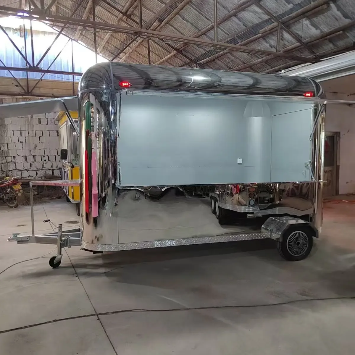 Mirror-finish trailer-style mobile food setup in a workshop